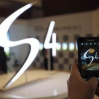 A man takes a photograph of a logo of Samsung Electronics Co Ltd’s latest flagship smartphone S4 during its launch event in Seoul