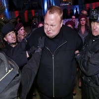 Actors in police costume mock-arrest Kim Dotcom as he launches his new website „Mega“ in Auckland