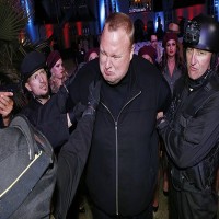 Actors in police costume mock-arrest Kim Dotcom as he launches his new website „Mega“ in Auckland