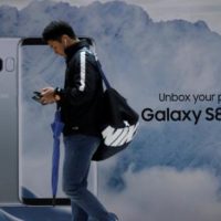 A man using his mobile phone walks past an advertisement promoting a Samsung Electronics‘ Galaxy S8 smartphone at a shop in Seoul